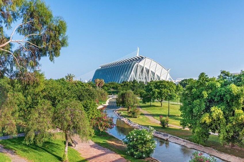 A modern building with a unique architectural design, surrounded by lush greenery and a small water feature. 5