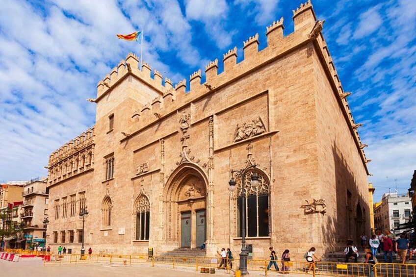 A historic building with ornate architecture, including a large arched entrance and decorative stonework. 2