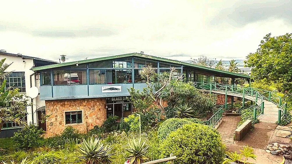 A building with a glass shop and a green bridge. 4