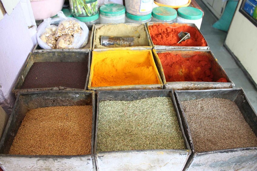 A variety of spices in metal containers. 5