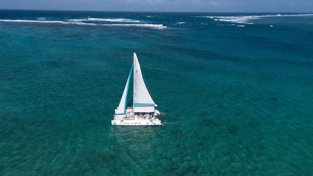 A sailboat in clear turquoise waters. 1