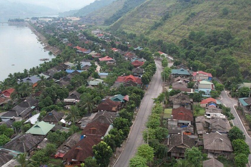 A coastal village with houses, a road, and a body of water. 2