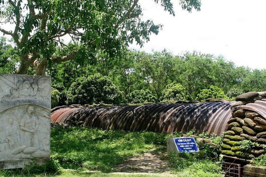 A stone structure with a relief, a water channel, and a sign. 3