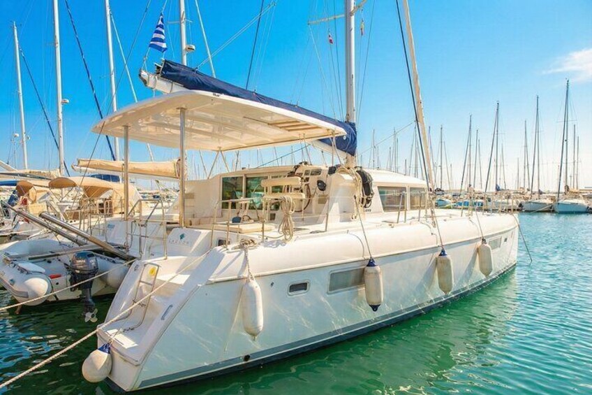 A white yacht docked at a marina with multiple sailboats in the background. 3