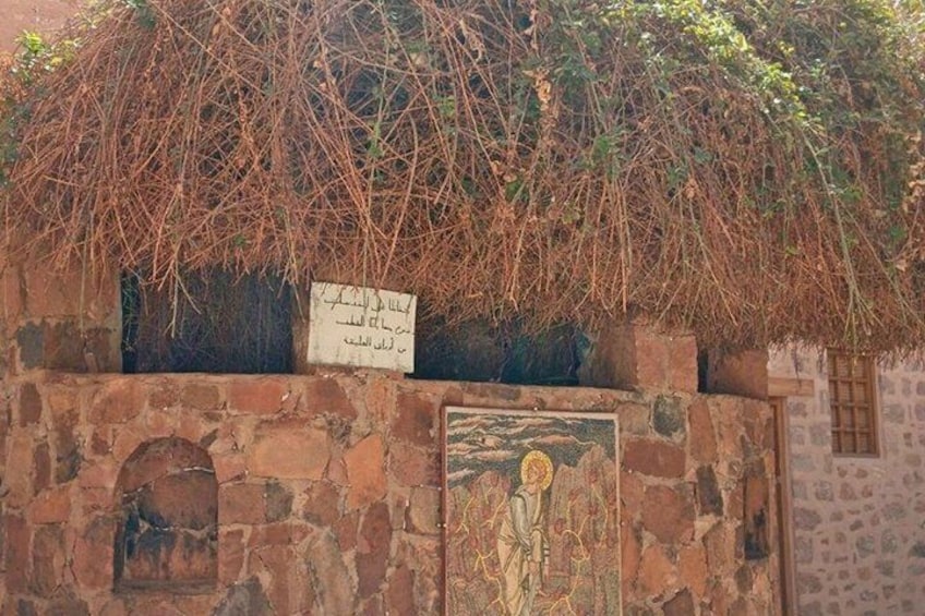 A stone wall with a mural and a sign. 5