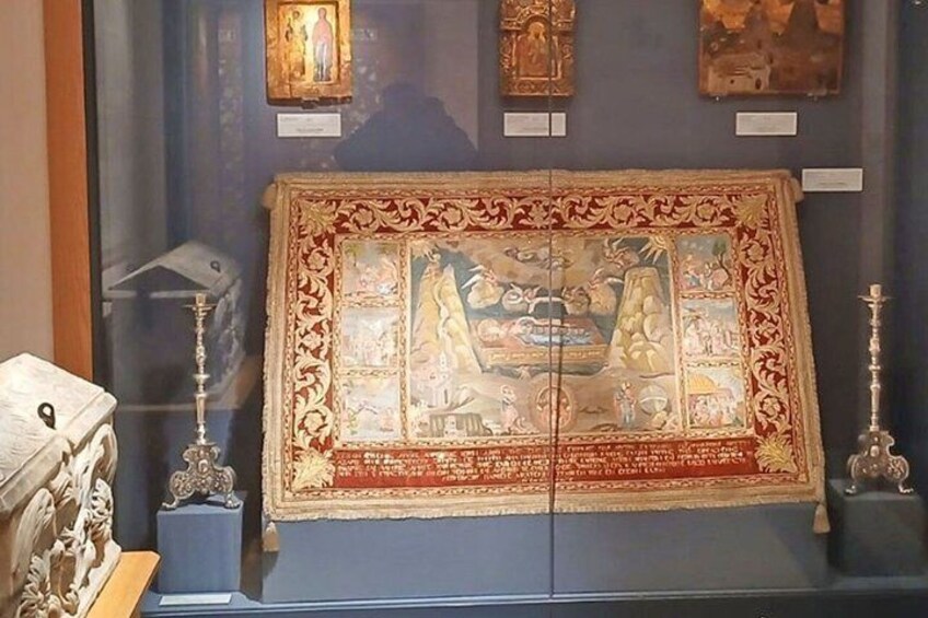 A framed mosaic with religious figures, surrounded by ornate candle holders. 4