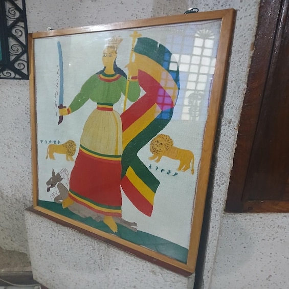 A framed painting of a figure with a staff, a lion, and a donkey. 3