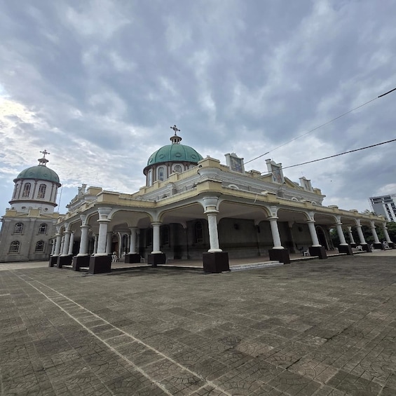 A historic building with a green dome and white columns. 1
