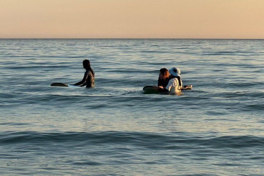 Three people in the ocean on surfboards. 3