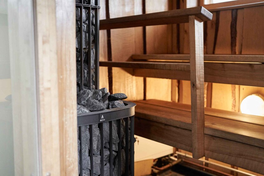 A wooden structure with a black trash bin and a circular light source in the background. 2
