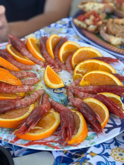 A plate of food with shrimp and orange slices. 4