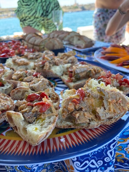 A table with food, including bread with toppings, and a person in the background. 3