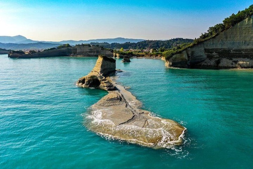 A river with clear turquoise water, rocky formations, and a cliff with vegetation. 4