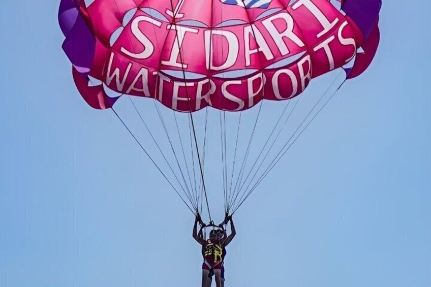 A person skydiving with a parachute labeled 'STUART WATERSPORTS.' 3