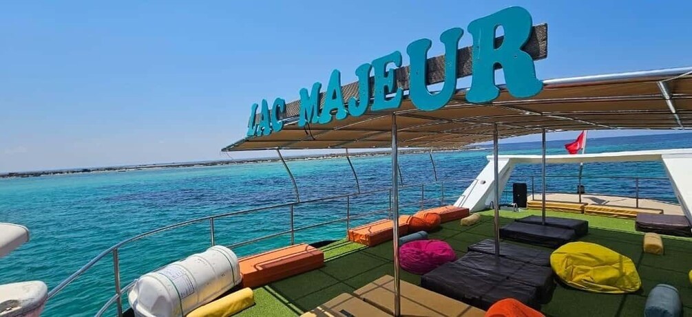 A boat deck with colorful cushions and a sign reading 'LAC MAJEUR.' 1