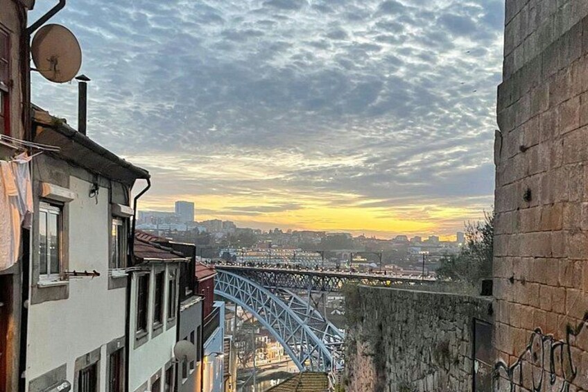 A cityscape with a bridge, buildings, and a sunset. 3
