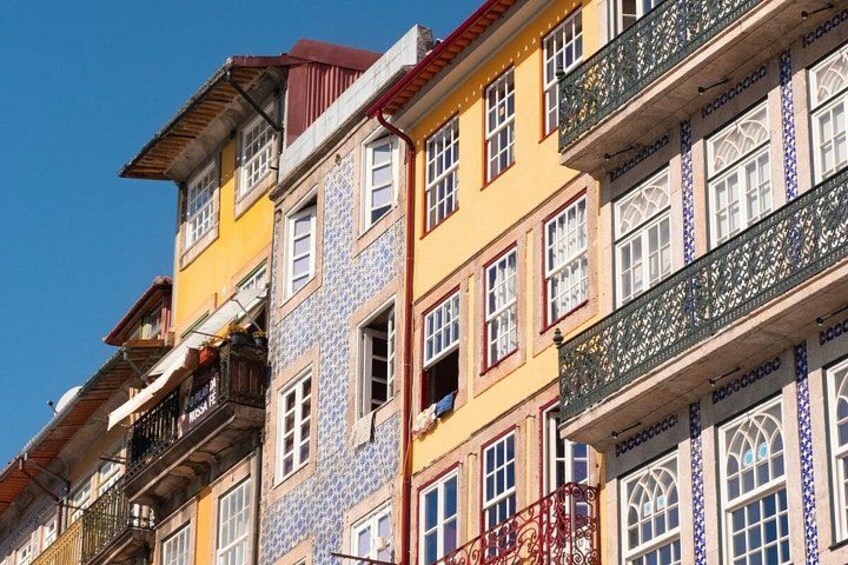 A row of colorful buildings with balconies and patterned tiles. 5
