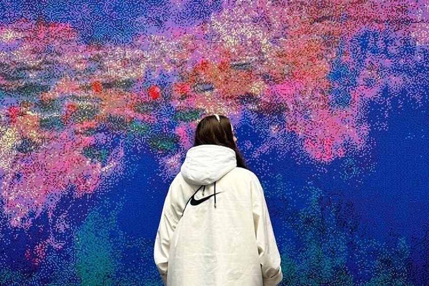 A person standing in front of a colorful abstract painting. 2