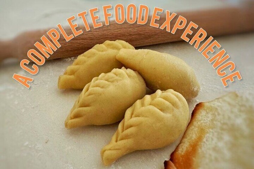 Three dumplings on a floured surface with a rolling pin and a piece of dough in the background. 1