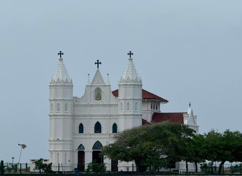 A white church with three towers and crosses. 5