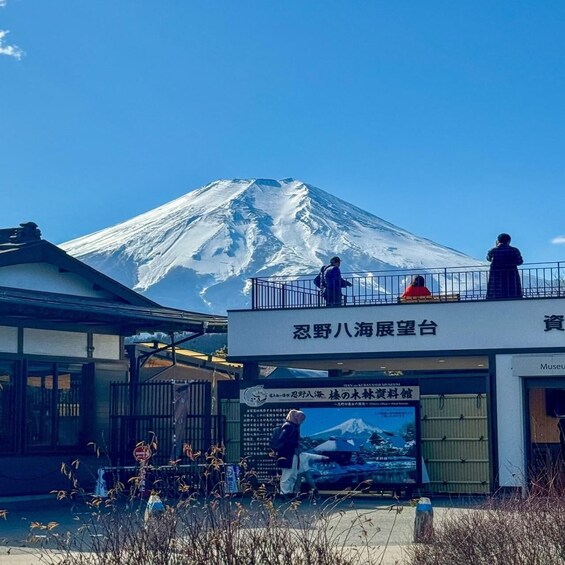 A snow-capped mountain, a viewing platform, and a museum with signage in a foreign language. 3