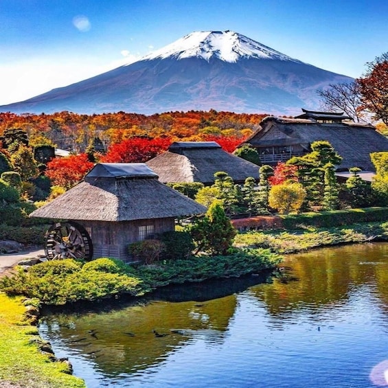 A traditional Japanese village with thatched-roof houses, a pond, and a mountain in the background. 5