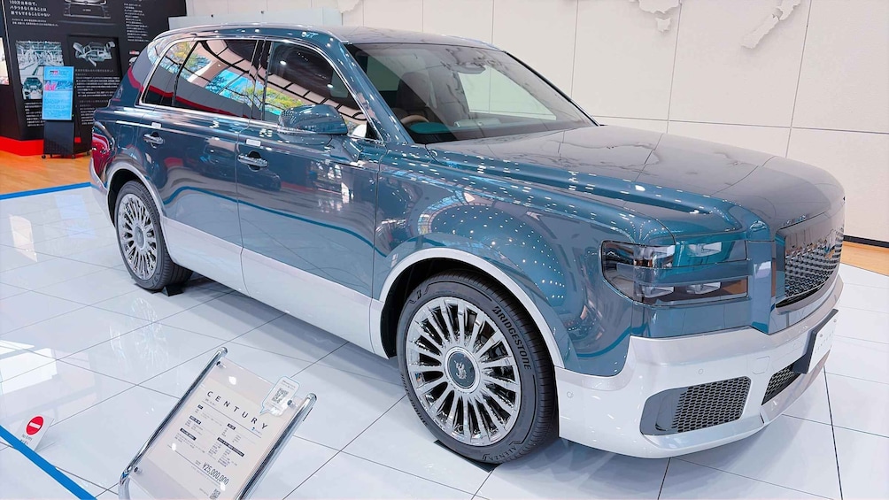 A luxury SUV with a distinctive grille and alloy wheels, displayed in a showroom. 5