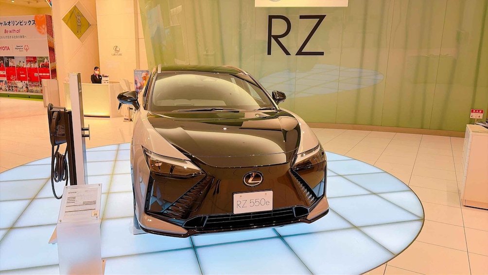 A luxury car on display with a sign reading 'RZ' in the background. 4