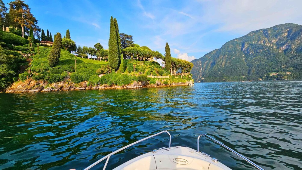 A boat on a calm lake with lush greenery and mountains in the background. 2