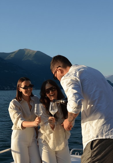Three people on a boat, one pouring a drink into a glass. 4