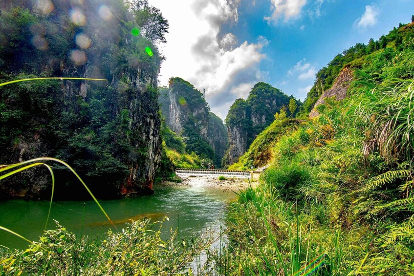 A river flowing through a lush valley with steep cliffs and dense vegetation. 2
