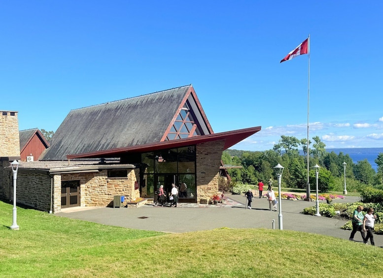 A stone building with a red roof and a flagpole. 4