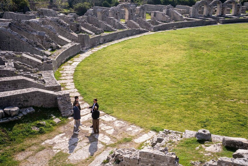 Ancient ruins with a grassy field and stone structures. 1