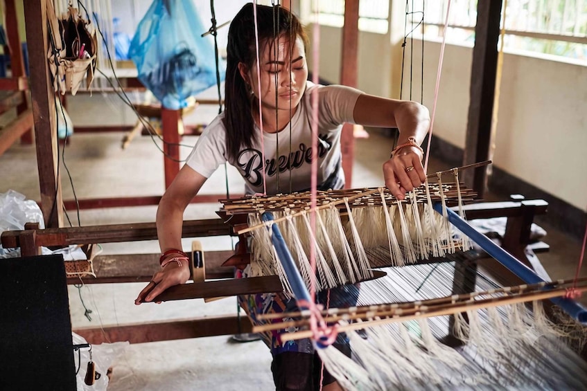 A person weaving on a loom. 1