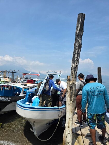 A dock with boats, people boarding, and a clear sky. 5