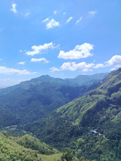 A mountainous landscape with lush greenery and a clear blue sky. 2