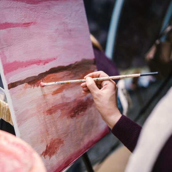A person painting on a canvas with a palette. 2
