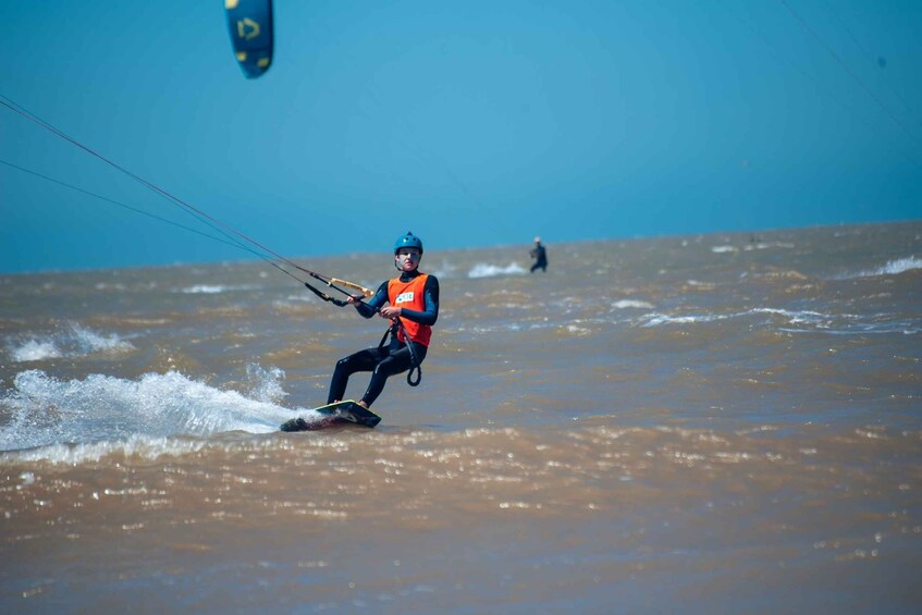 A person windsurfing on a choppy body of water. 1