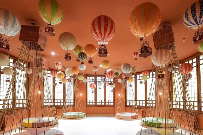 A room with hanging hot air balloons and traditional Japanese tatami mats. 4