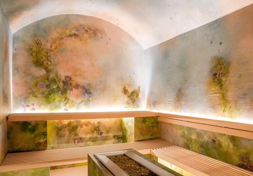 A room with a mural, benches, and a water feature. 5