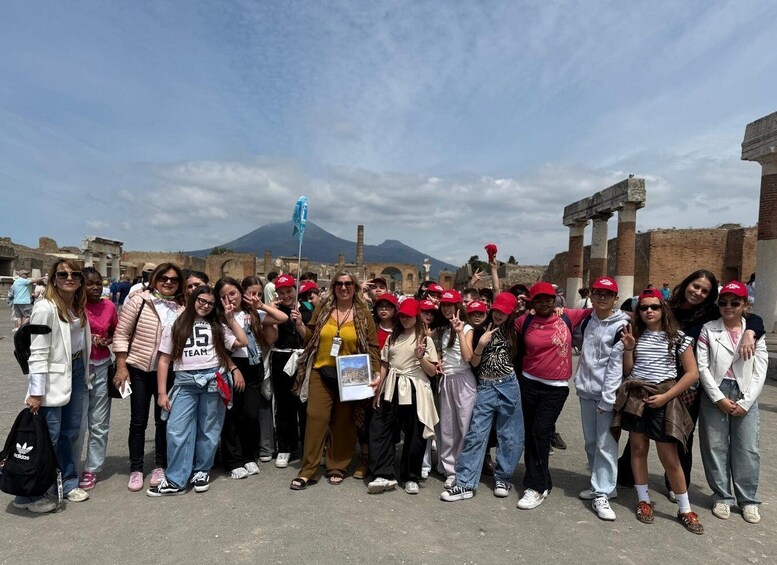 A group of people posing in front of ancient ruins with a mountain in the background. 2
