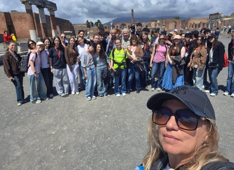 A group of people standing in front of ancient ruins with columns and stone structures. 3