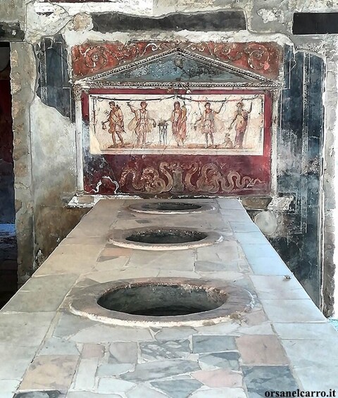 A historical site with a mosaic and stone-lined walkway. 4