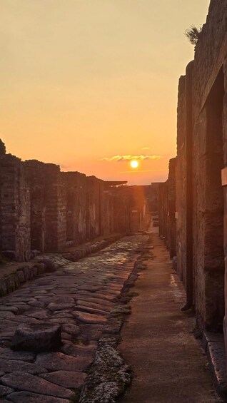 A stone pathway flanked by ancient walls at sunset. 5