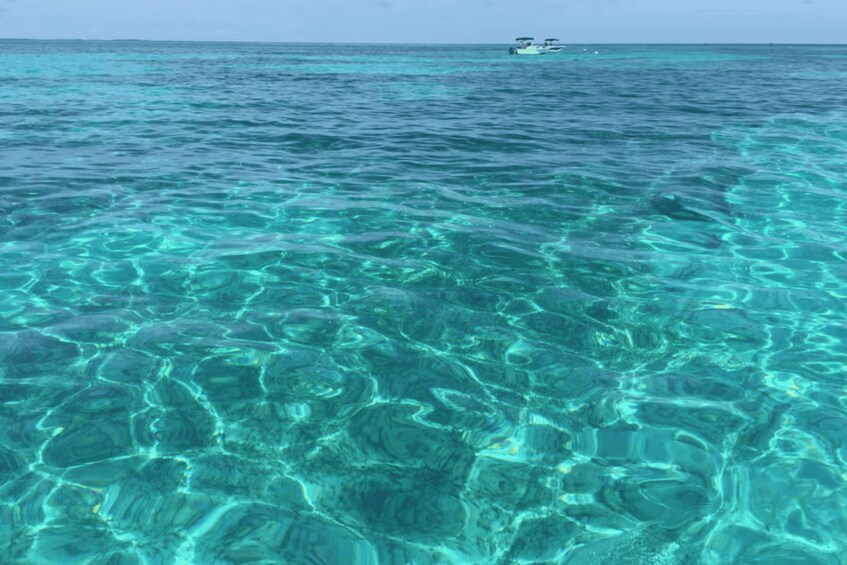 Clear turquoise water with a boat in the distance. 2