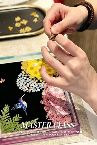 A person crafting a pressed flower art piece. 1