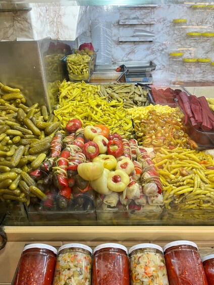 A variety of pickled vegetables and condiments in glass jars. 2
