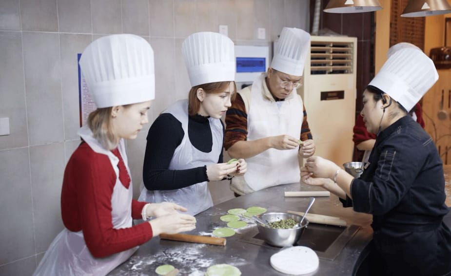Chefs in white hats preparing food in a kitchen. 5