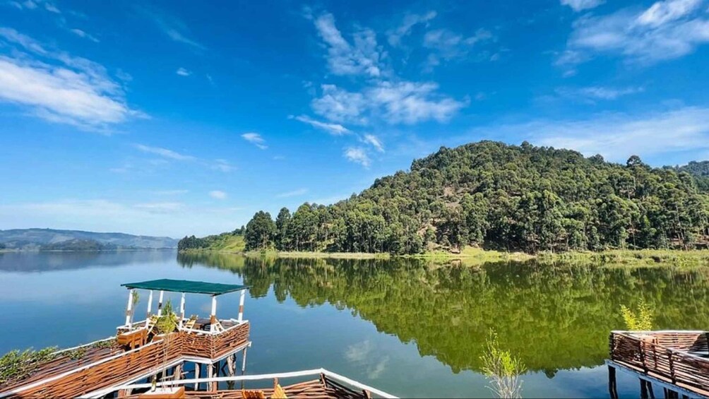 A calm lake with a wooden dock and a forested hill in the background. 3