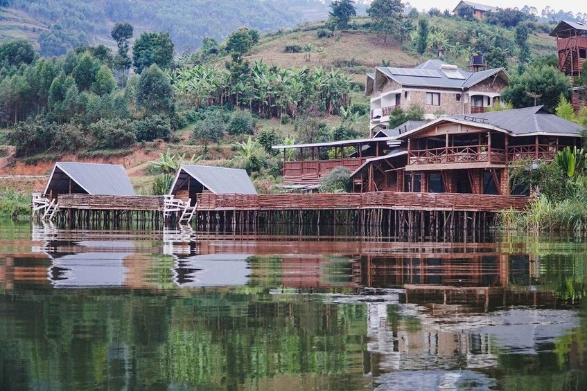 A house on stilts over water, surrounded by lush greenery and hills. 2
